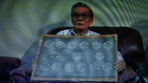 Mr. Hoàng Phượng holding a paper mold with a security watermark